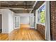 Bright living room with exposed brick and hardwood floors leads to an open layout with multiple large windows at 3235 Roswell Ne Rd # 521, Atlanta, GA 30305