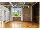 Bright living area with hardwood flooring, exposed brick, and scenic outdoor views visible from large windows at 3235 Roswell Ne Rd # 521, Atlanta, GA 30305