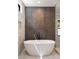 Bathroom with soaking tub, tiled walls, and a window for natural light at 4091 Oak Forest Ne Dr, Brookhaven, GA 30319