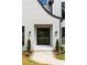 Modern black framed glass front door with stone paver entry way and trimmed bushes at 4091 Oak Forest Ne Dr, Brookhaven, GA 30319