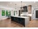 Spacious kitchen with a waterfall island, seating, and views of the backyard through black-framed windows at 4091 Oak Forest Ne Dr, Brookhaven, GA 30319