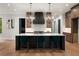 Modern kitchen with a dark island, white countertops, wooden cabinets, and sleek, pendant lighting at 4091 Oak Forest Ne Dr, Brookhaven, GA 30319