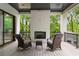 Covered outdoor deck with white brick fireplace and two rocking chairs overlooking a wooded area at 4091 Oak Forest Ne Dr, Brookhaven, GA 30319
