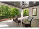 Covered outdoor deck with ceiling fan and two rocking chairs overlooking a scenic wooded area at 4091 Oak Forest Ne Dr, Brookhaven, GA 30319