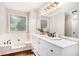 Bright bathroom features a large mirror, vanity, and soaking tub near a window at 110 Peach Pointe Dr, Mcdonough, GA 30253