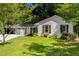 Lovely single-story home with white brick, green door, dark shutters, mature landscaping and a green lawn at 3176 Gablewood Ct, Decatur, GA 30033