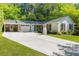 Inviting single-story home with white brick, dark shutters, attached garage, and a long driveway at 3176 Gablewood Ct, Decatur, GA 30033