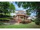 Multi-level deck with a landscaped backyard featuring a grassy area and lush greenery at 3845 Winters Hill Dr, Atlanta, GA 30360