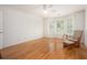Well-lit bedroom with hardwood floors, shutters, and a comfy rocking chair at 3845 Winters Hill Dr, Atlanta, GA 30360