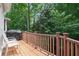 View of a deck with a grill and chair, surrounded by lush greenery and trees at 3845 Winters Hill Dr, Atlanta, GA 30360