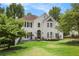 Elegant two-story home with manicured landscape and decorative front door with a lush green lawn and white facade at 3845 Winters Hill Dr, Atlanta, GA 30360