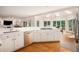 Open kitchen with hardwood floors, white cabinets, stainless appliances, and an eating area at 3845 Winters Hill Dr, Atlanta, GA 30360