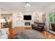 Bright living room featuring hardwood floors, a fireplace, built-in shelving, and backyard access at 3845 Winters Hill Dr, Atlanta, GA 30360