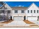 Charming townhomes with gray and white exteriors, garages, and well-maintained landscaping at 405 Carrera Ln, Acworth, GA 30102