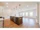 A modern kitchen with a large island, wooden floors, pendant lights and stainless steel appliances at 405 Carrera Ln, Acworth, GA 30102
