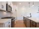 Well-lit kitchen with white cabinets, stainless steel appliances, an island with sink, and modern lighting at 405 Carrera Ln, Acworth, GA 30102