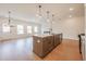 Spacious living room with large windows, a modern island kitchen, and stylish pendant lighting at 405 Carrera Ln, Acworth, GA 30102