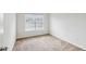 Bright bedroom featuring neutral carpet, a large window with blinds, and fresh neutral paint at 5273 High Tide Ct, Atlanta, GA 30349