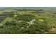 Aerial view of a neighborhood surrounded by lush green forests and large open green spaces at 9179 Selborne Ln, Chattahoochee Hills, GA 30268