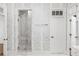 Modern bathroom featuring glass shower and patterned wallpaper at 9179 Selborne Ln, Chattahoochee Hills, GA 30268