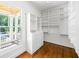 Walk-in closet with custom shelving, drawers, and a view to the outside deck at 9179 Selborne Ln, Chattahoochee Hills, GA 30268
