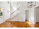 Bright foyer featuring hardwood floors, staircase with white railing and an abundance of natural light at 9179 Selborne Ln, Chattahoochee Hills, GA 30268
