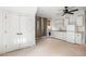 A carpeted laundry room with white cabinets, a washing machine, a small fridge, a sink, and double door closets at 9179 Selborne Ln, Chattahoochee Hills, GA 30268