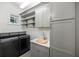Gray laundry room featuring a washer and dryer, sink and storage at 9179 Selborne Ln, Chattahoochee Hills, GA 30268