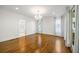 Spacious living room with hardwood floors, white walls, recessed lighting, and decorative chandelier at 9179 Selborne Ln, Chattahoochee Hills, GA 30268