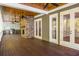 A screened in porch with a stone fireplace, a wood planked ceiling, outdoor kitchen and wood floors at 9179 Selborne Ln, Chattahoochee Hills, GA 30268