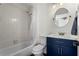Clean bathroom with a shower/tub combo, white tile, and navy vanity at 1028 Riverbend Club Se Dr, Atlanta, GA 30339