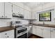 Well-lit kitchen with white cabinets, stainless steel appliances and updated countertops at 1028 Riverbend Club Se Dr, Atlanta, GA 30339