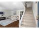 Bright living room with hardwood floors, a cozy sectional, and a staircase leading to the upper level at 1028 Riverbend Club Se Dr, Atlanta, GA 30339