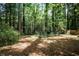 A spacious, wooded backyard with a chainlink fence is partially shaded by mature trees at 1819 King Alfred Sw Dr, Atlanta, GA 30331