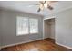 Bedroom features hardwood floors and trim, large window, and ceiling fan at 1819 King Alfred Sw Dr, Atlanta, GA 30331