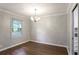 Bright dining area with hardwood floors, a chandelier, and a large window offering natural light at 1819 King Alfred Sw Dr, Atlanta, GA 30331