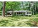 Charming brick home featuring a covered carport and a well-maintained, green front lawn at 1819 King Alfred Sw Dr, Atlanta, GA 30331