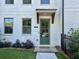 Charming townhouse entrance with a painted white brick facade and a decorative sage-green door at 2893 Elmwood Dr, Smyrna, GA 30080