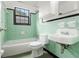 Retro bathroom featuring a tub, toilet, and sink with classic green and black tile at 323 8Th Ne St # 7, Atlanta, GA 30309