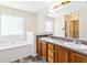 Primary bathroom with double sinks, separate soaking tub, and a tile backsplash at 4065 Waters End Ln, Snellville, GA 30039