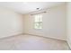 A simple bedroom with neutral carpet and walls features a single window at 4065 Waters End Ln, Snellville, GA 30039