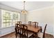 Elegant dining room featuring a wooden table, decorative chandelier, and wainscoting along the walls at 4065 Waters End Ln, Snellville, GA 30039