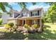 Two-story home with gray siding, black shutters, brick accents, and a colorful, landscaped front yard at 4065 Waters End Ln, Snellville, GA 30039