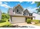 View of the exterior featuring two story facade, gray siding, garage door, and a well-manicured yard at 4065 Waters End Ln, Snellville, GA 30039