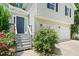 Inviting home entrance with a blue front door, steps, and lush landscaping at 5590 Princeton Oaks Dr, Sugar Hill, GA 30518
