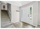 Bright entryway featuring wood-look floors, a staircase, and a coat rack at 5590 Princeton Oaks Dr, Sugar Hill, GA 30518