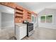 Quaint kitchen featuring exposed brick, open shelving, and views of the backyard at 5590 Princeton Oaks Dr, Sugar Hill, GA 30518