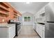Charming kitchen with exposed brick, open shelving, stainless steel appliances, and a view to the backyard at 5590 Princeton Oaks Dr, Sugar Hill, GA 30518