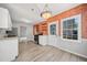 Well-lit kitchen features exposed brick, open shelving, modern appliances, and backyard view at 5590 Princeton Oaks Dr, Sugar Hill, GA 30518