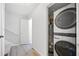 Hallway with laundry closet featuring stacked washer and dryer, plus hot water tank at 5590 Princeton Oaks Dr, Sugar Hill, GA 30518